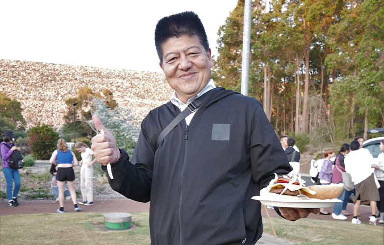 City of Moka Council Chairman Takayuki Kushige with a burger at the Welcome Function