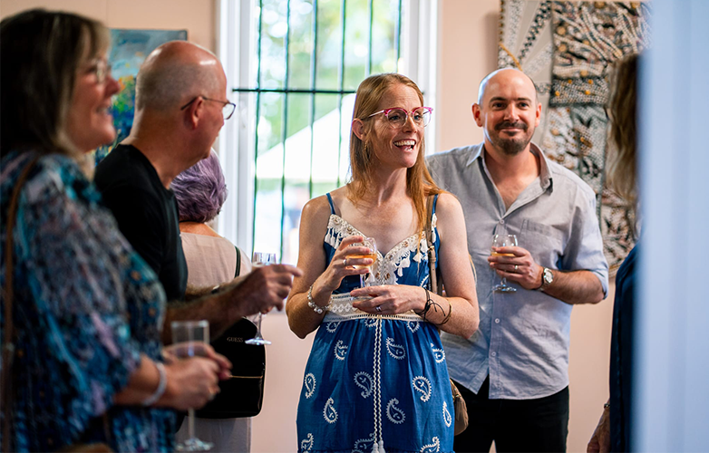 Guests take time to study the diverse artworks on display, each reflecting the theme From the Land, From the Heart.