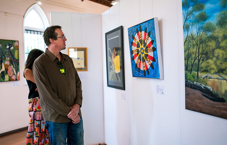 Visitors explore the 2026 Shire of Harvey Art Prize exhibition inside the historic former Church of Our Lady of Immaculate Conception.